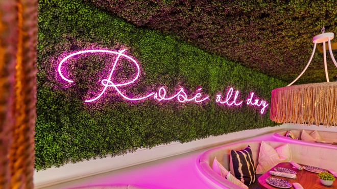 A pink neon sign that reads "Rosé all day"