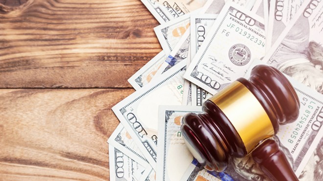 Stock photo of a judge's gavel on a pile of money